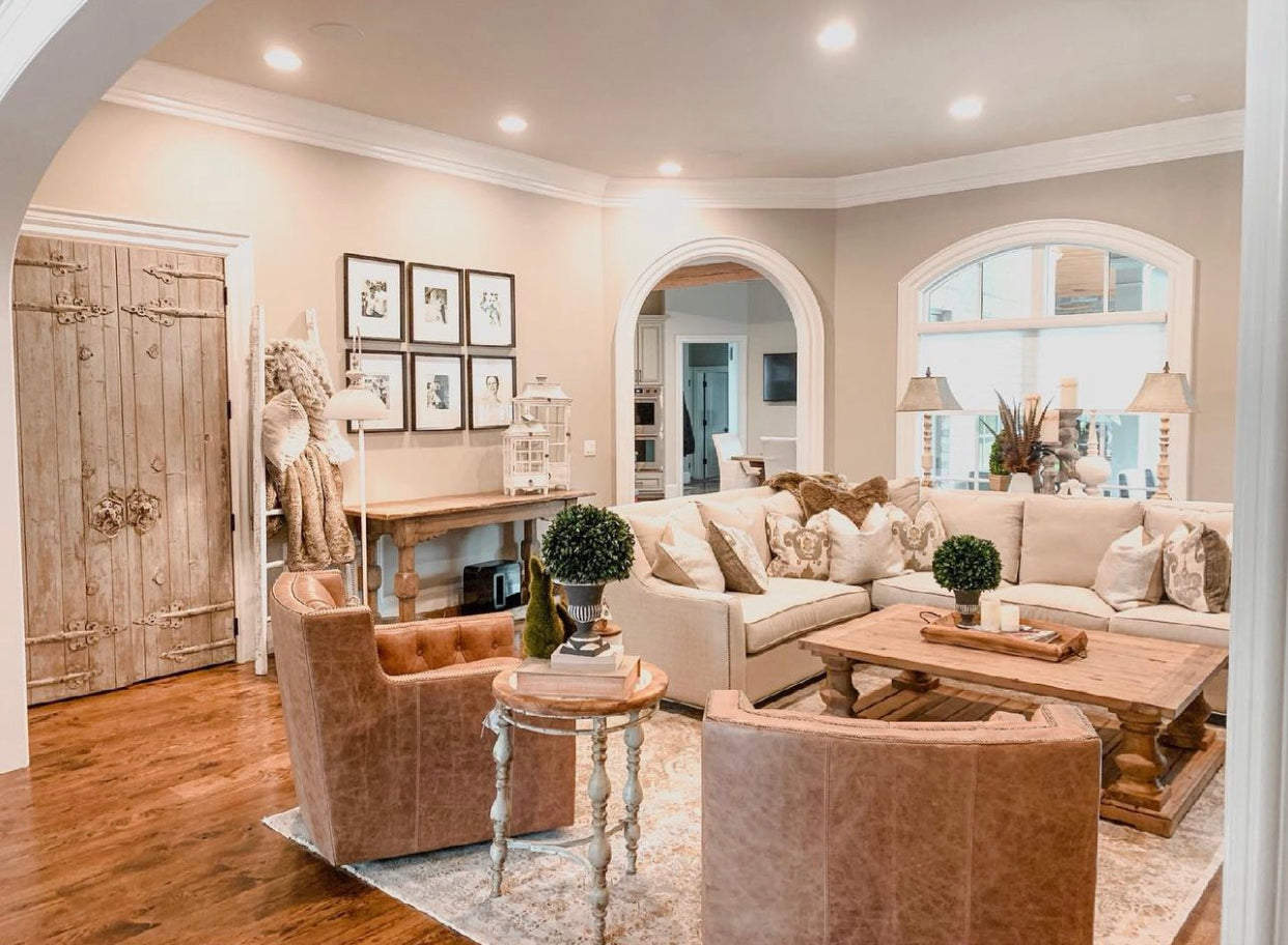 leather chairs with cream sectional, pillows, plants, and coffee table
